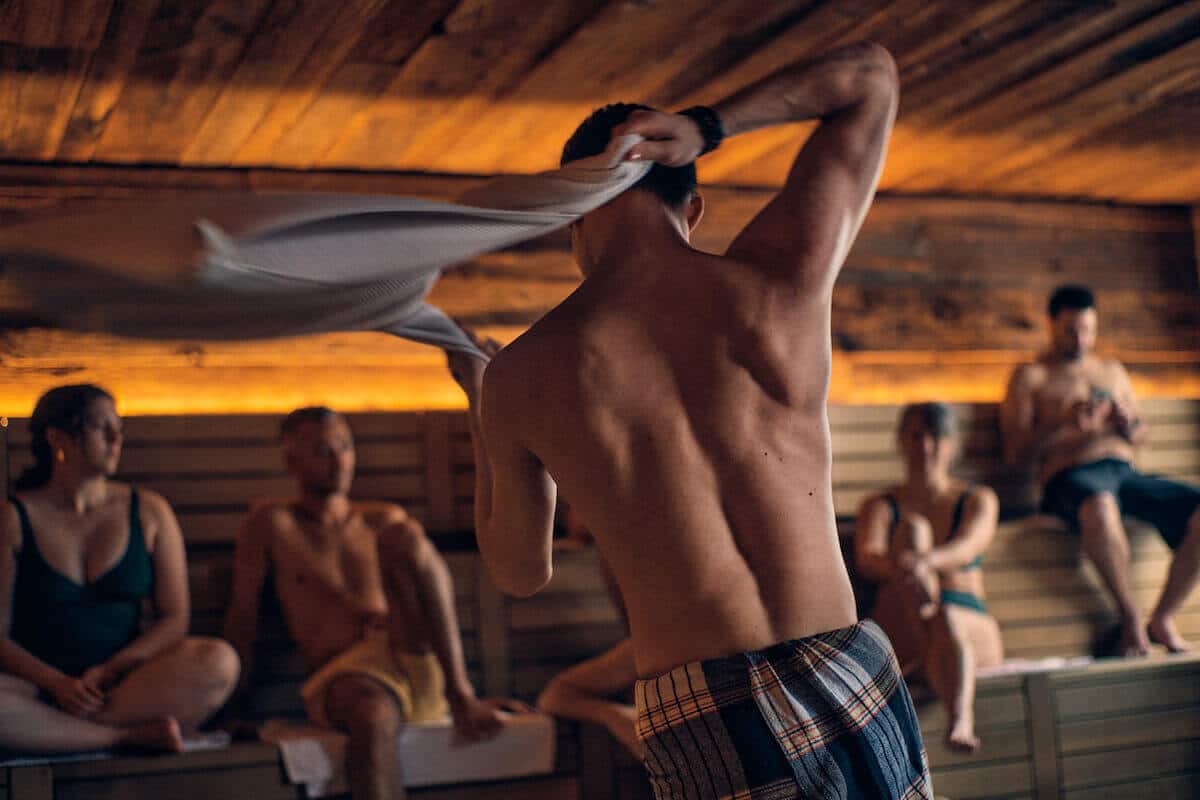 Man swirling a towel in an Aufguss sauna ritual at Le Nordik spa in Chelsea, Quebec.