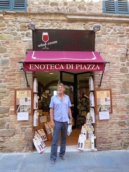 Man outside a shop selling Brunello wine in Montalcino Italy