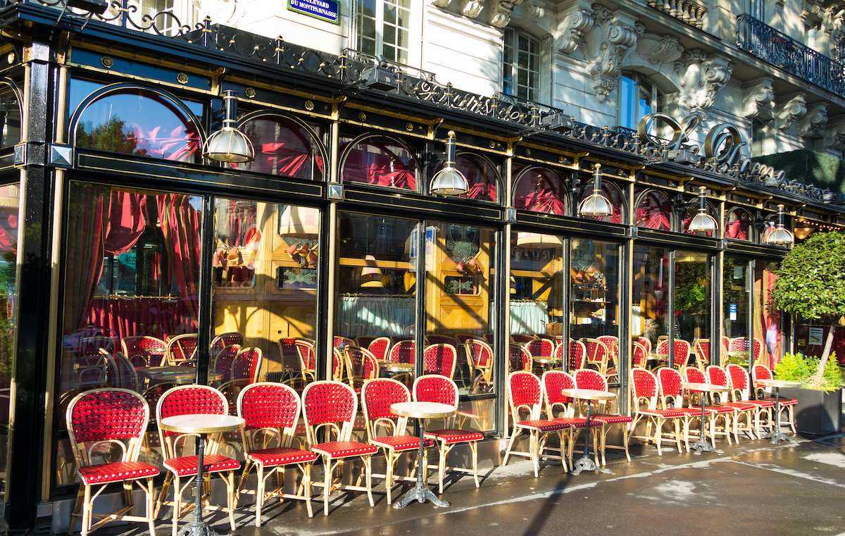 Le Dome Cafe in Paris with red seats in sunshine.