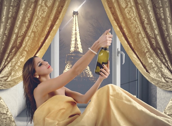 Beautiful woman with champagne in a luxury hotel room