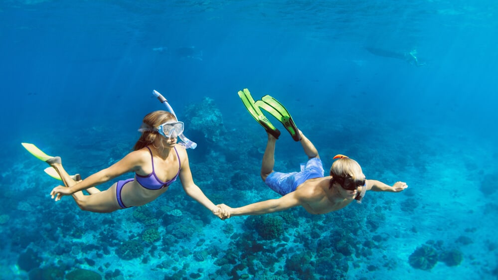 young couple snorkelling in the blue Caribbean sea