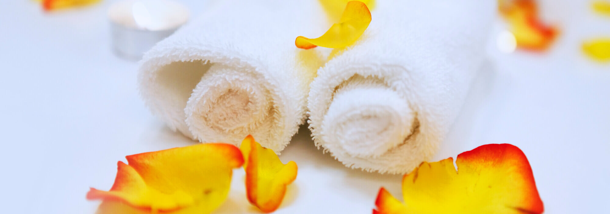 white rolled towels and orange blossoms at a spa