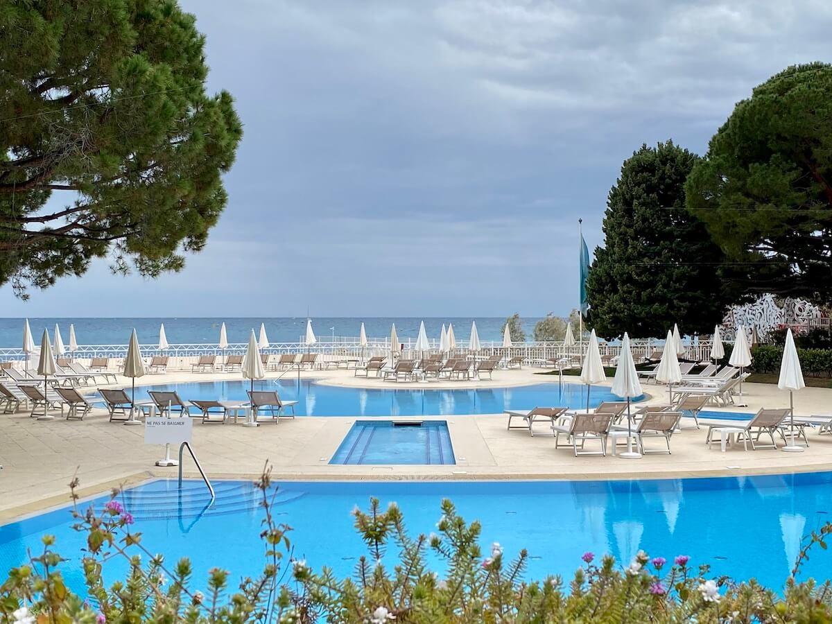 Beautiful 5 star Monaco hotel with white deck chairs and distant sea