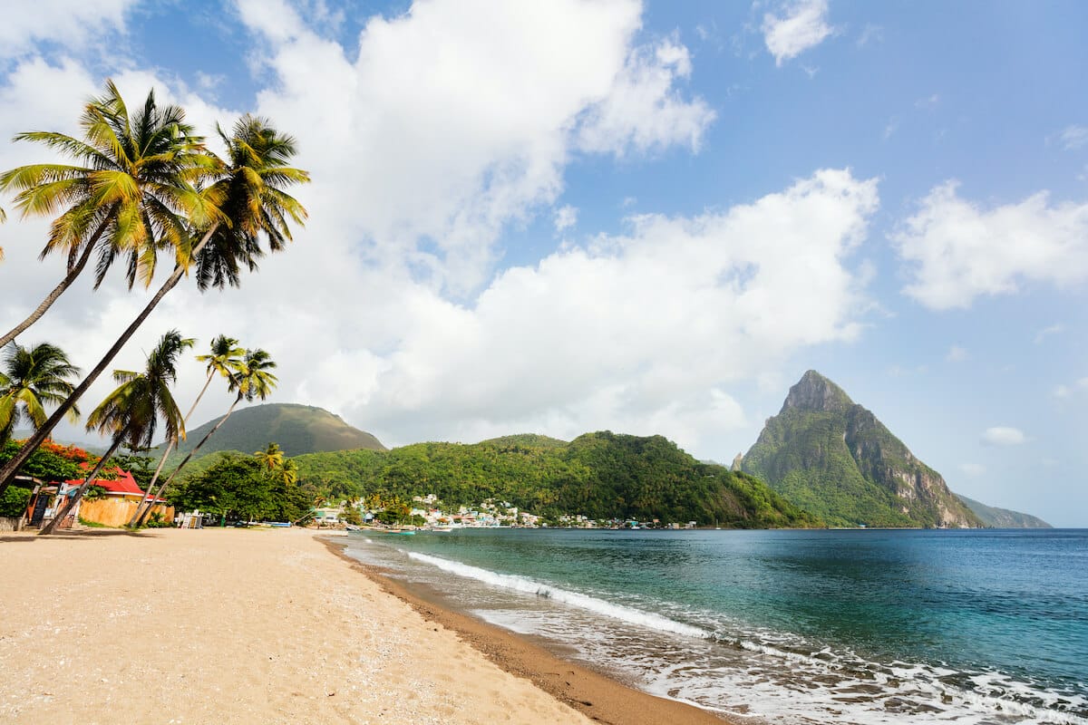 Golden sand beach with palm trees and Gros Piton mountain