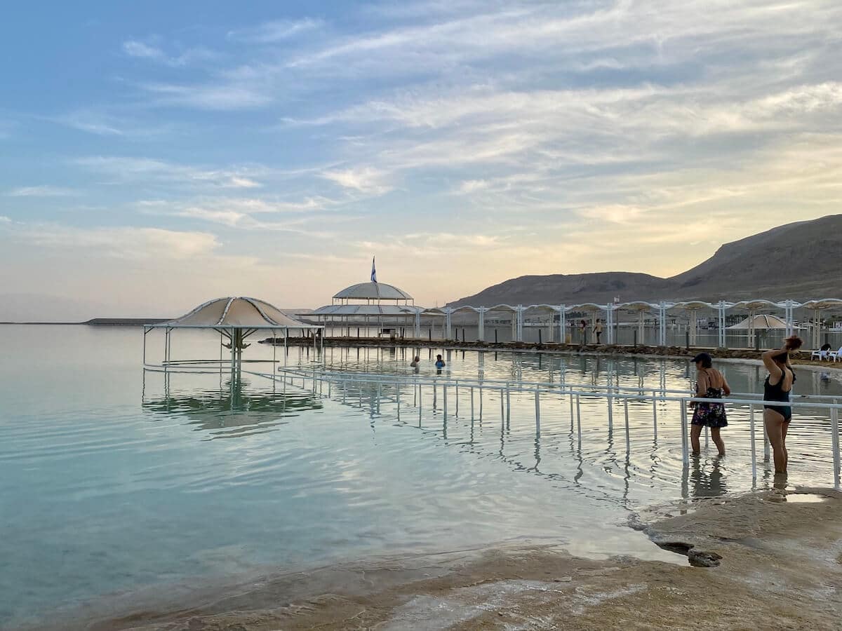 Serene shot of Ein Bokek at sunset with people stepping into the water