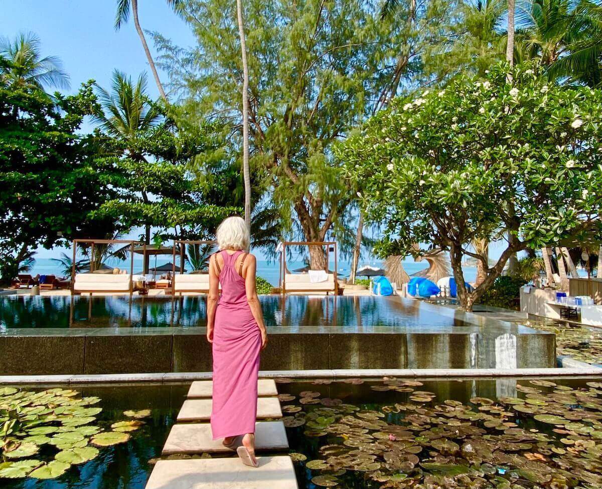 Blond woman in long dress at the Black Pool at Sala Samui Choengmon