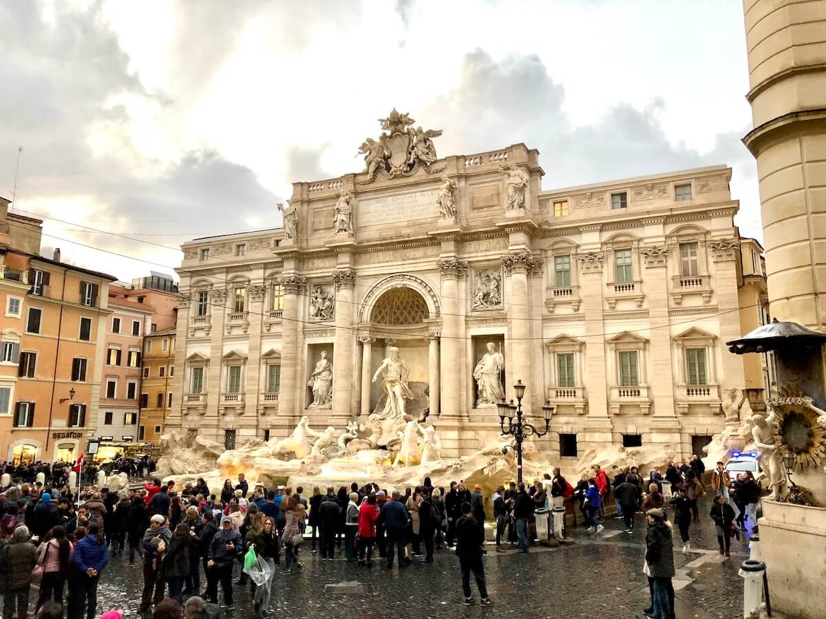 Crowds on a cloudy day at Trevi Fountain in Rome