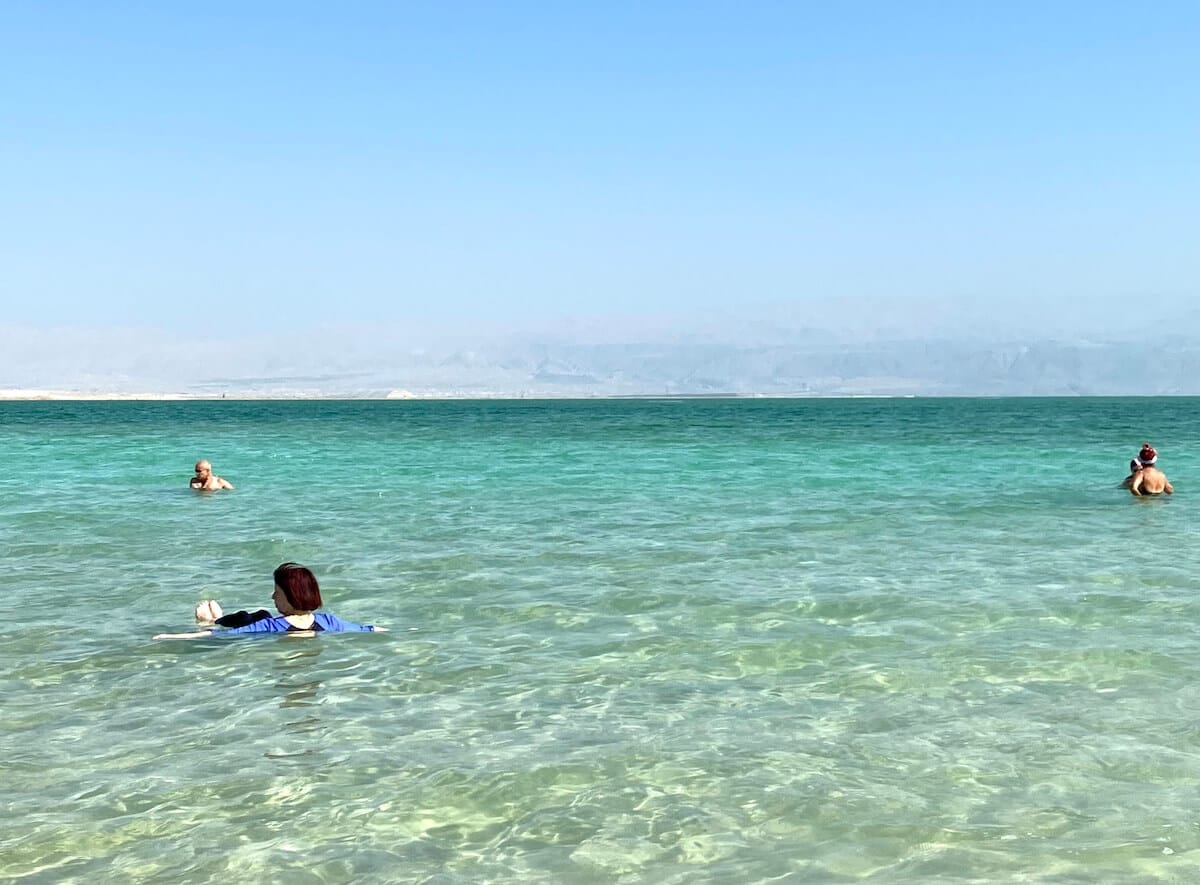 Woman floating in the clear water of the Dead Sea