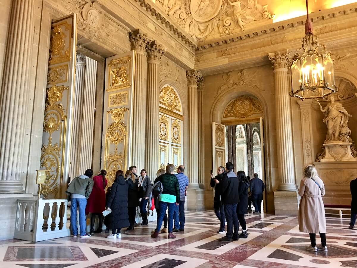 Tour group on a Versailles day trip in an ornate room