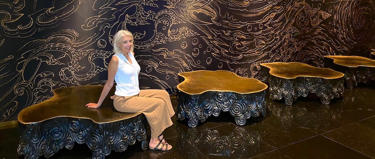 Carol Perehudoff sitting in a gold and black room
