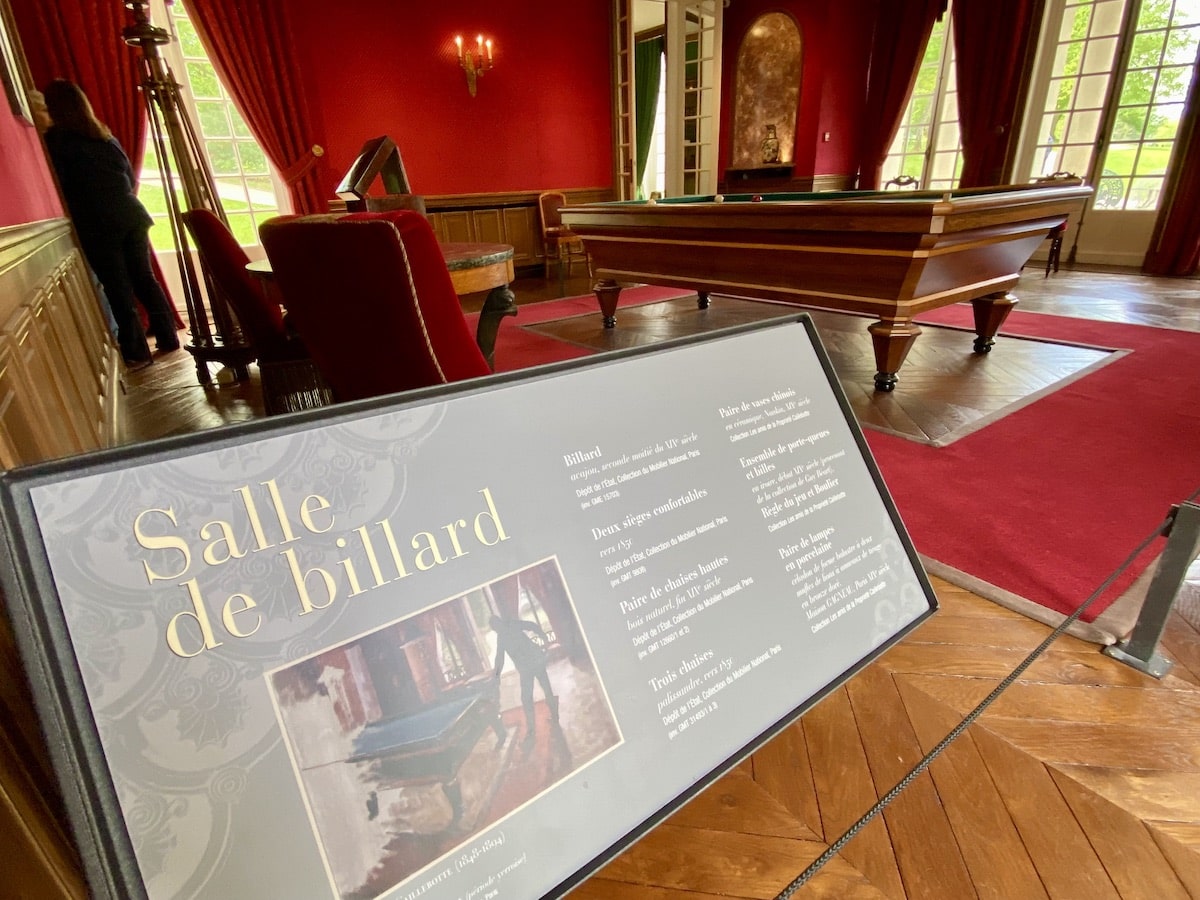 Billiard room from the 19th century with rich red decor.