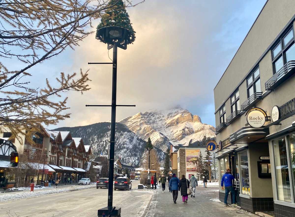 Banff Avenue in winter with mountains behind.